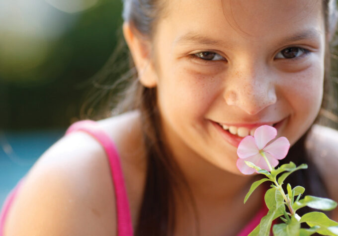 Girl smelling flower at summer camp