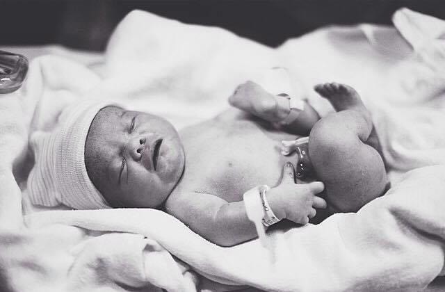 A black and white photo of newborn Jude.