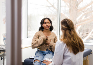 Teen girl privately discussing symptoms with a female doctor