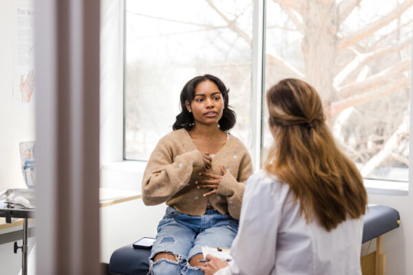 Teen girl privately discussing symptoms with a female doctor