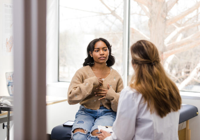 Teen girl privately discussing symptoms with a female doctor