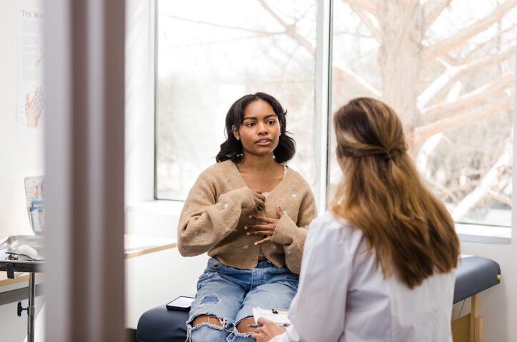 Teen girl privately discussing symptoms with a female doctor