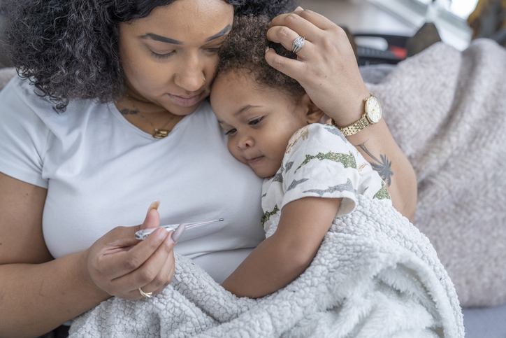Mother snuggles her little boy who is not feeling well.
