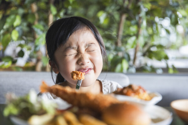 girl making a face while eating a vegetable