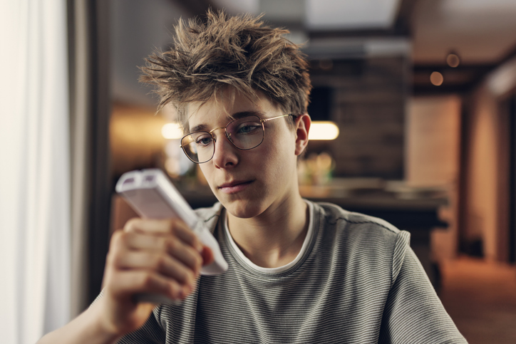 Teenage boy monitoring peak expiratory flow rate with a peak flow meter to manage asthma during Asthma Peak Week in September