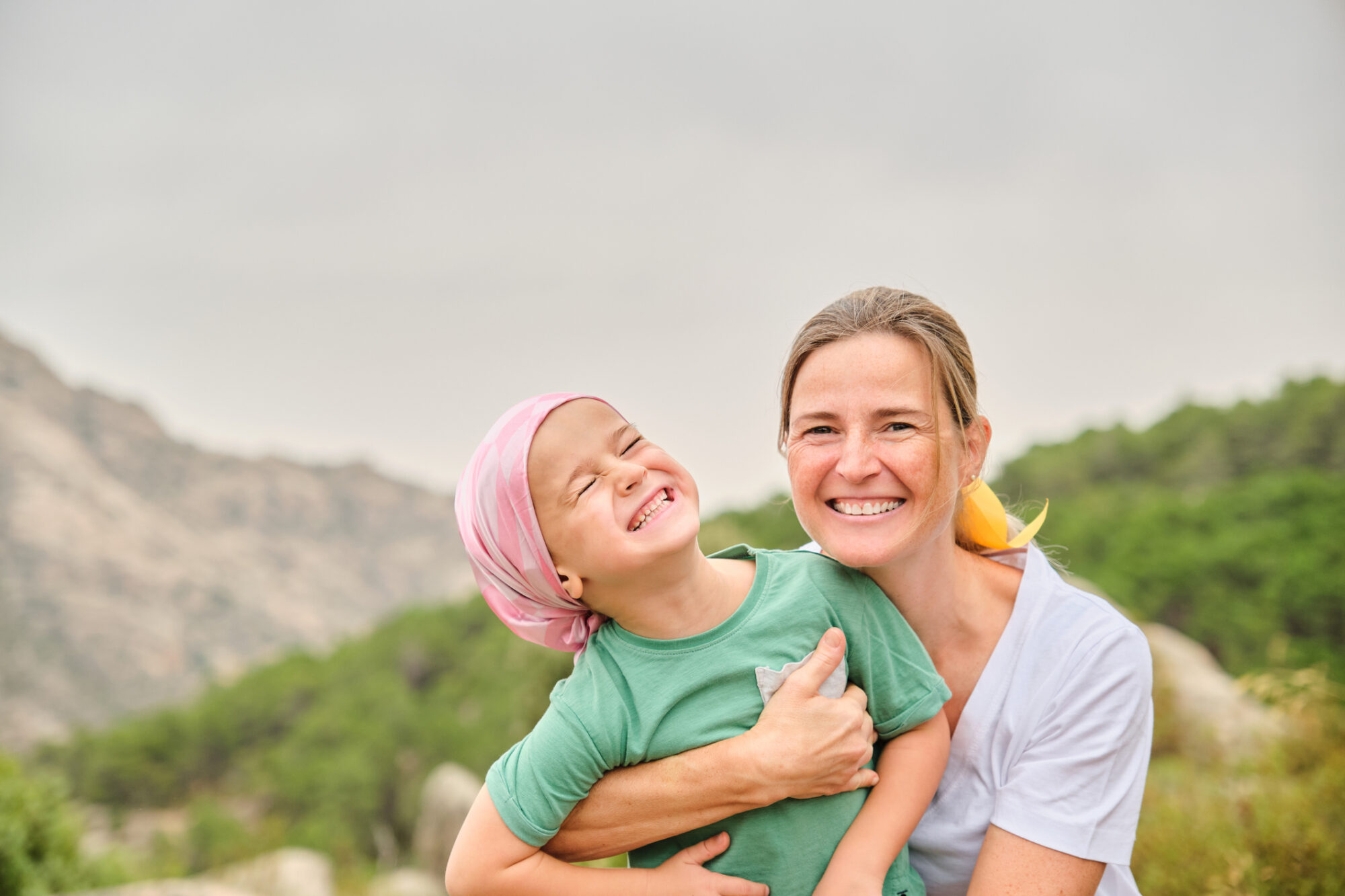 Pediatric cancer patient bonding with family in nature showcasing the importance of emotional support during care.