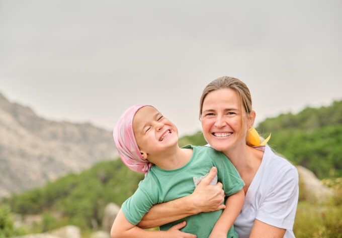 Pediatric cancer patient bonding with family in nature showcasing the importance of emotional support during care.