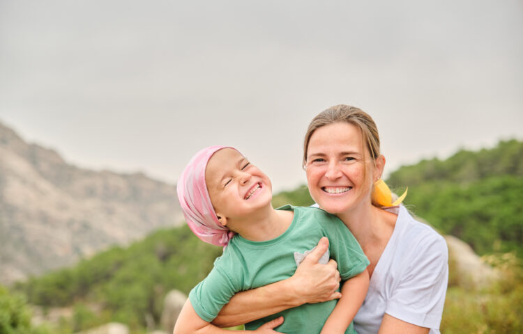 Pediatric cancer patient bonding with family in nature showcasing the importance of emotional support during care.