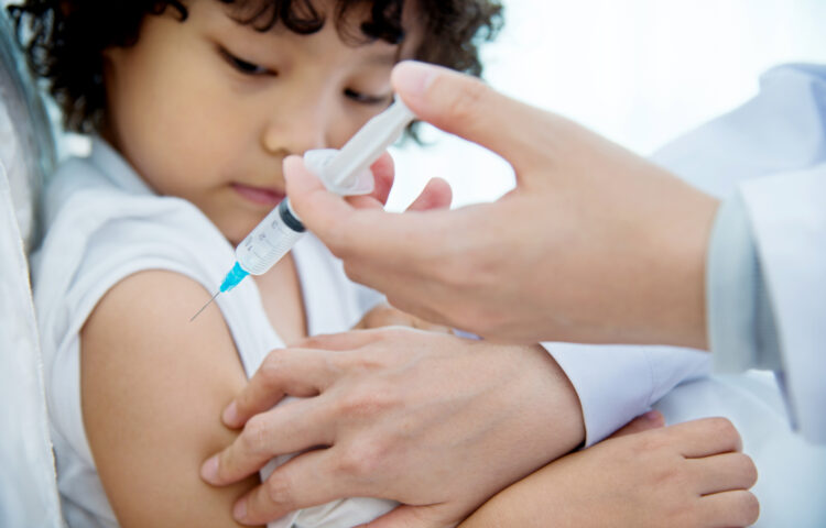 Young boy getting flu vaccine at the doctor's office