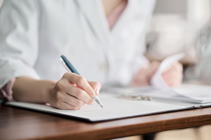 Hands of researcher taking notes during a study
