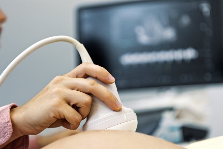 Young female doctor performing ultrasound on a pregnant woman