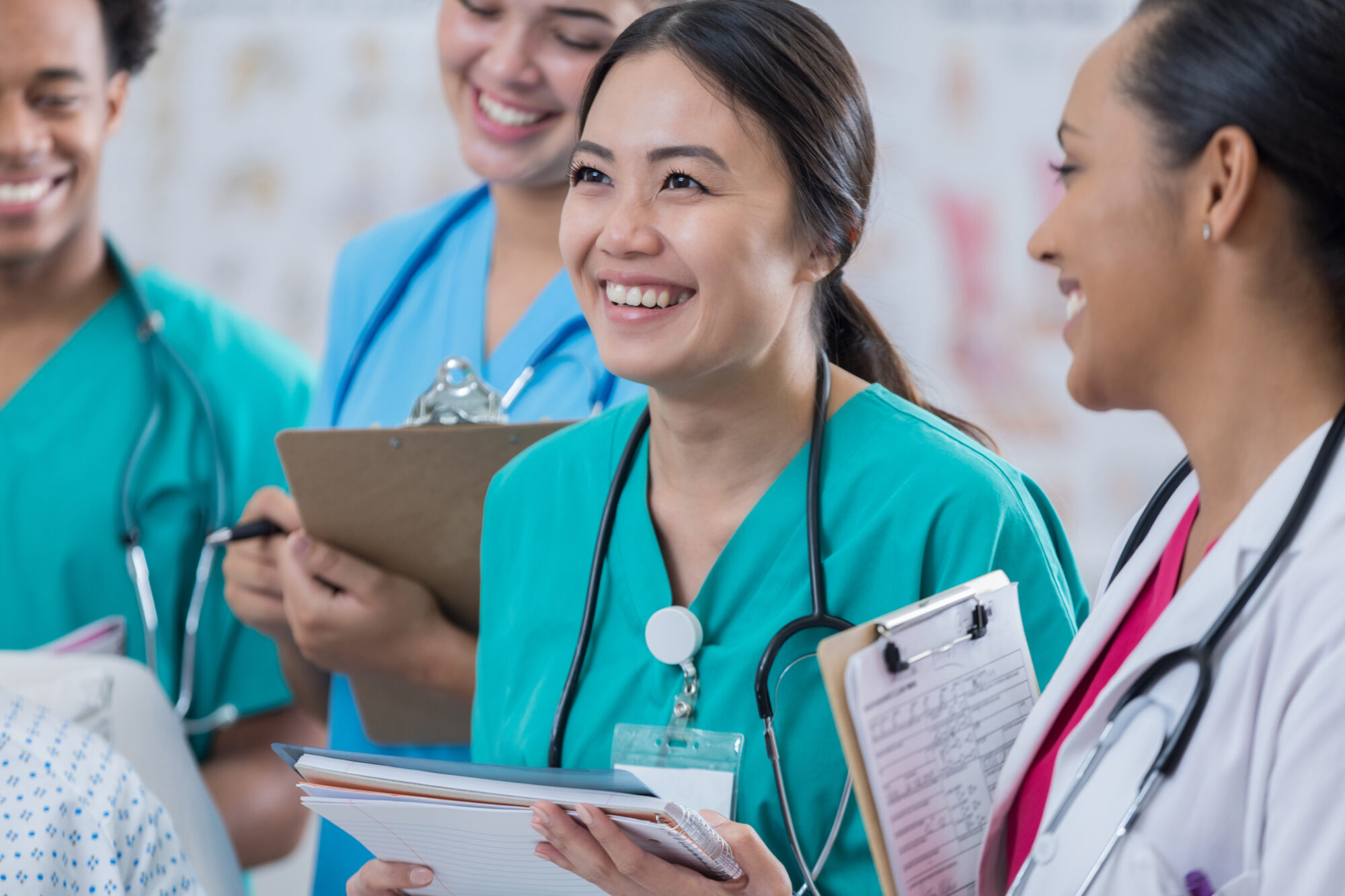 Cheerful female medical intern participates in hospital rounds with experienced female physician.