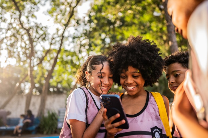 Young athlete showing social media to friends on a mobile phone at the public park