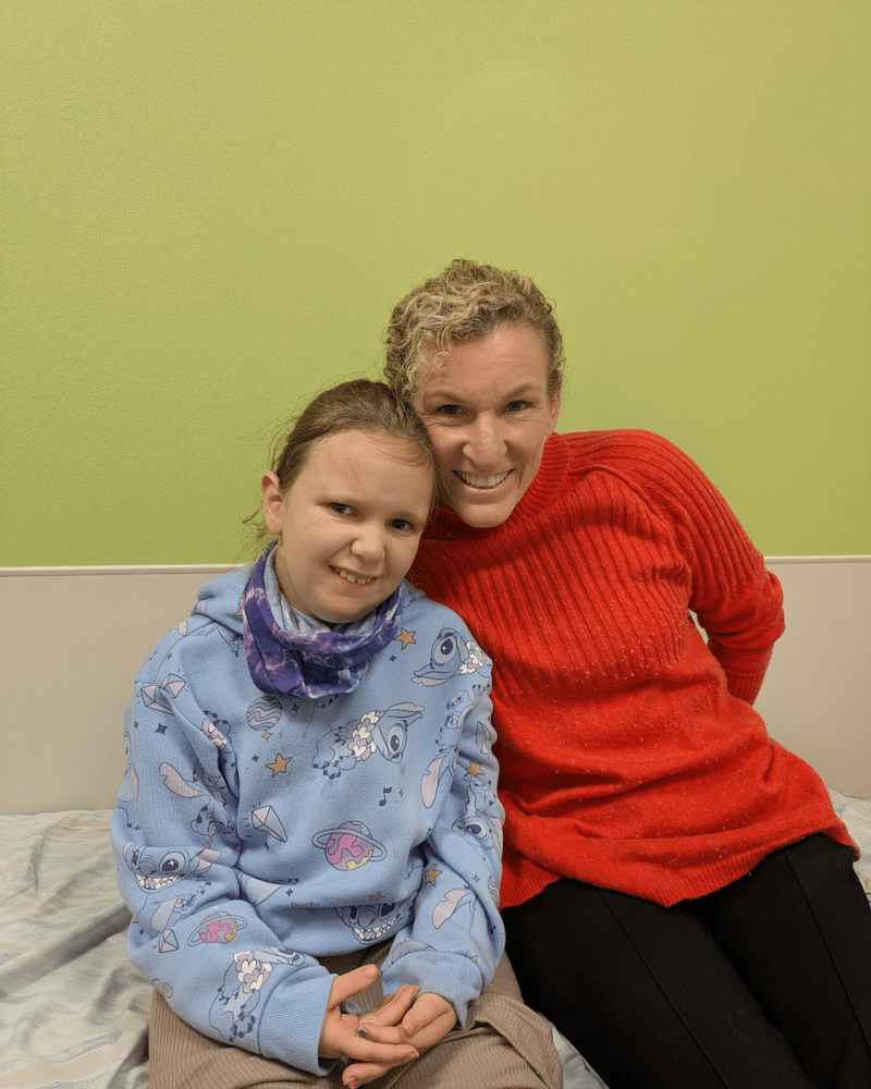 Young girl smiles with her doctor in a clinic room for a photo