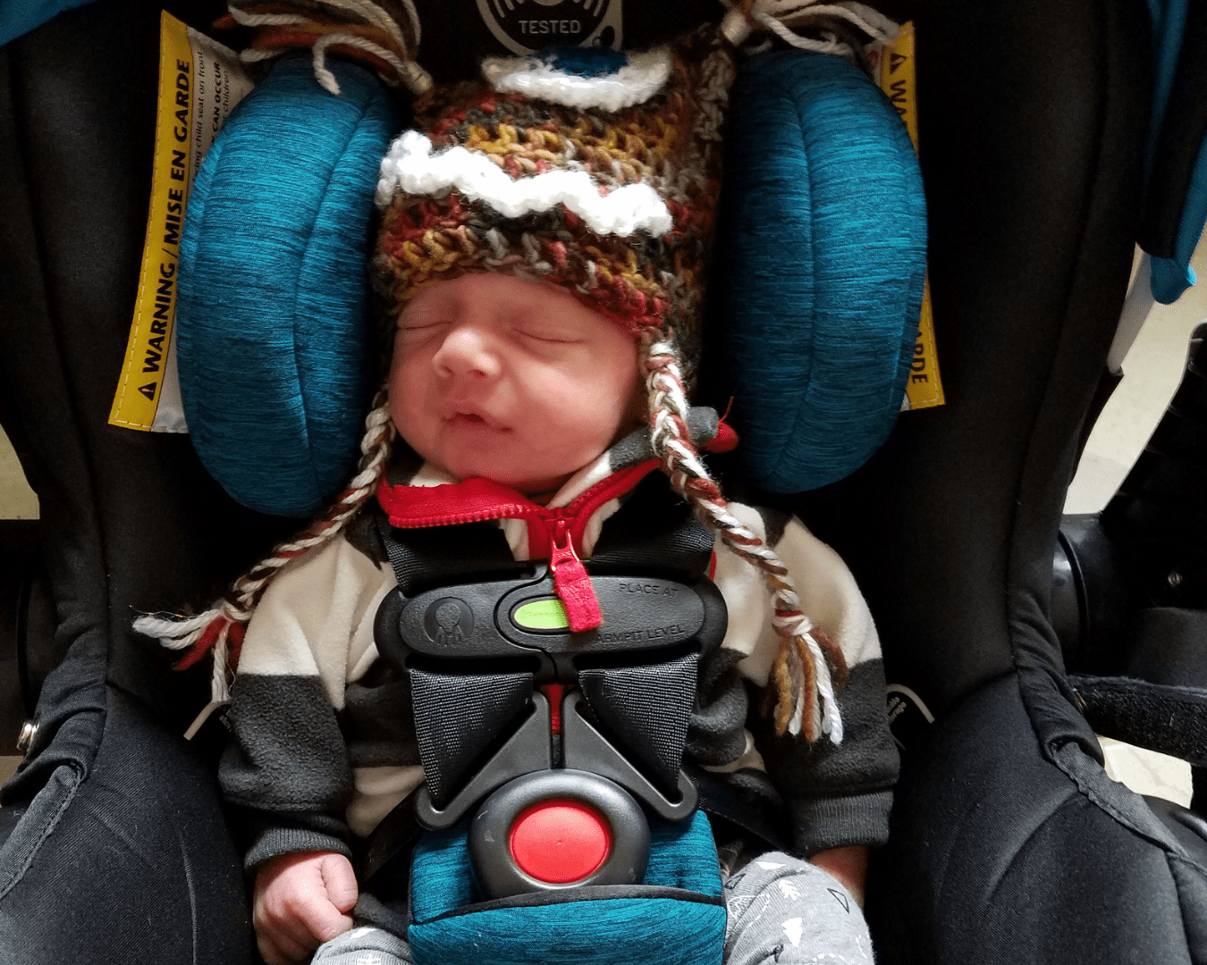 Photo of a child in a car seat wearing a beanie