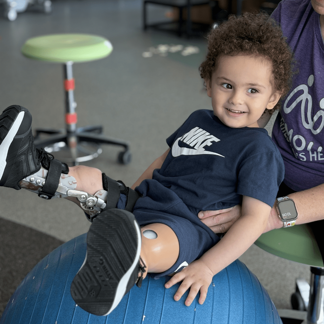 Boy with prosthetic leg participates in physical therapy
