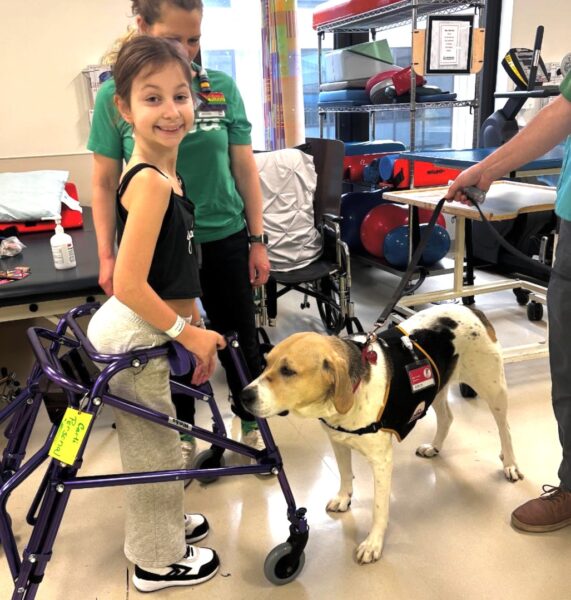 Child patient in recovery with a therapy dog.