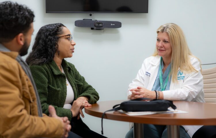 Mother and father are speaking with a genetic counselor about prenatal testing.