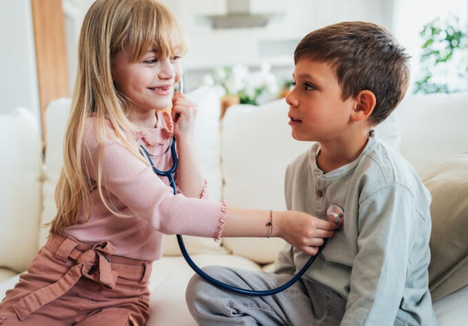 Little kids pretending to be a doctor. Shot of a cute little girl with a stethoscope examining her brother. Children playing doctors.