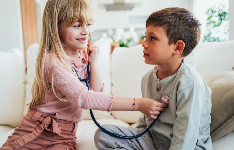 Little kids pretending to be a doctor. Shot of a cute little girl with a stethoscope examining her brother. Children playing doctors.