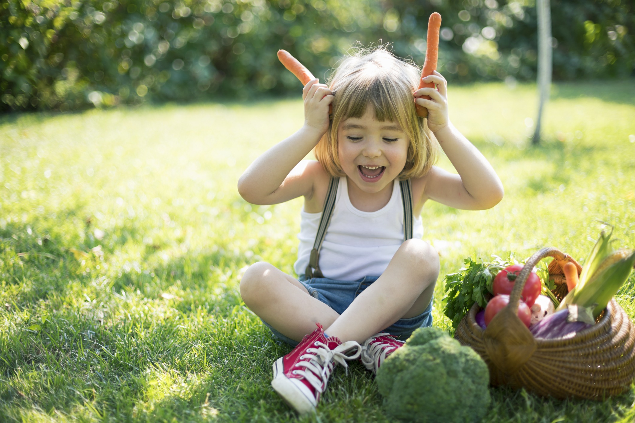 Cute child with a basket of organic vegetables