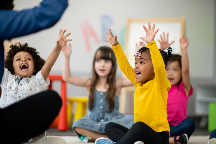 Kids sitting on the floor at circle time at preschool or daycare.