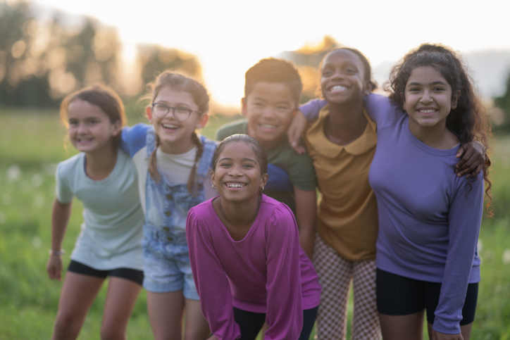 Group of children standing together outdoors, connecting and spending time with peers