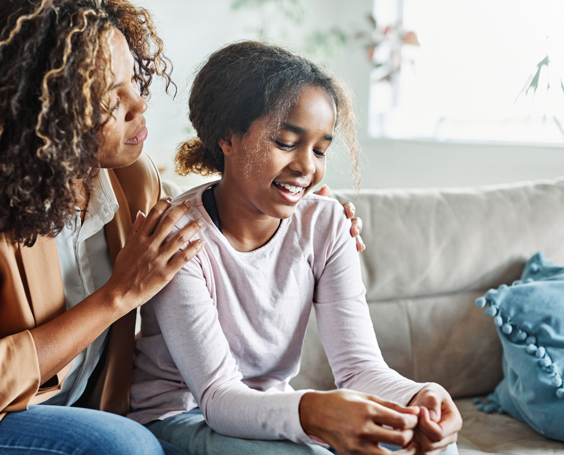 Adult sitting with a child on a couch, offering comfort and support at home