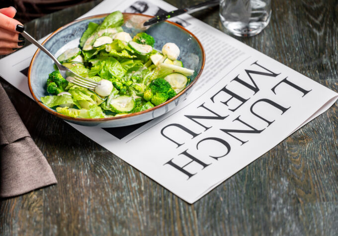 Fresh salad on a newspaper representing headlines about produce safety and the recent cyclosporiasis outbreak linked to fresh produce.