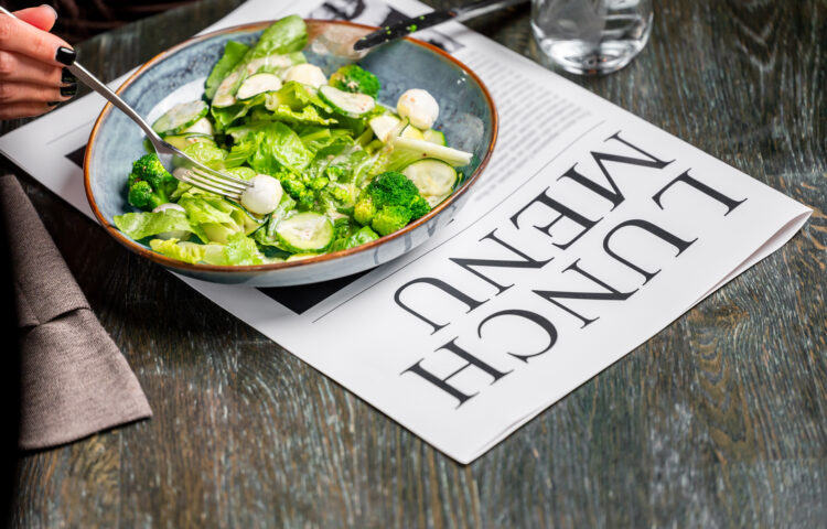 Fresh salad on a newspaper representing headlines about produce safety and the recent cyclosporiasis outbreak linked to fresh produce.