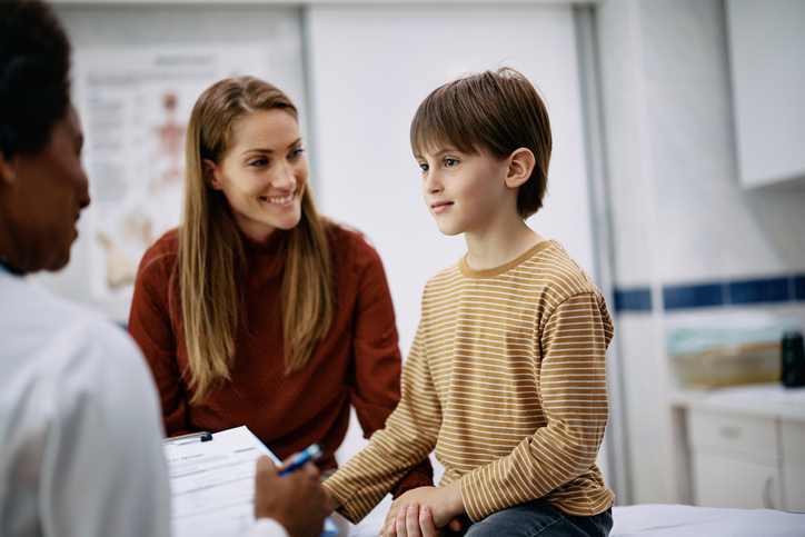Child and parents speaking with a healthcare provider during an ADHD evaluation appointment.