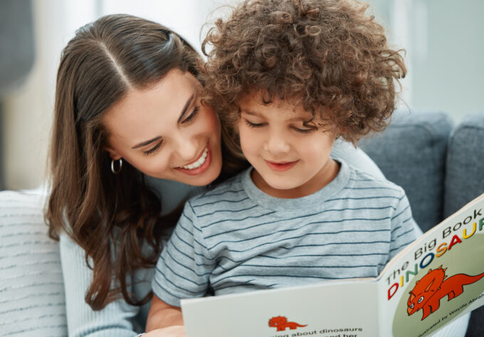 Adult reading a children's book with a young child while sitting together at home.
