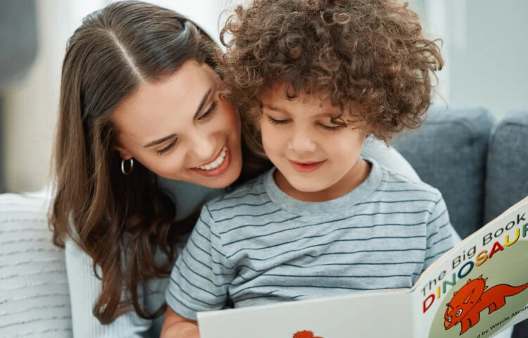 Adult reading a children's book with a young child while sitting together at home.